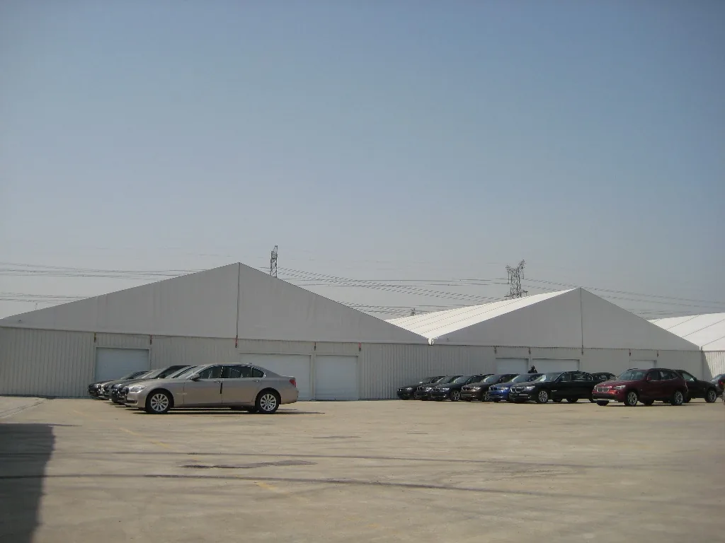 White clear-span warehouse tents installed on a paved industrial site